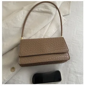 Brown woven baguette bag showing inner capacity compared with a smartphone