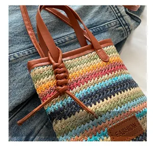 Macro detail of rainbow woven straw bag with leather straps and decorative knot