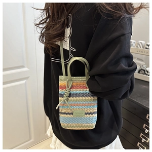 Detail der bunten Regenbogen-Stroh-Handtasche mit grünen Ledergriffen und Fashion-Logo