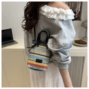 Detail der bunten gewebten Mini-Eimertasche mit Ledergriff und Fashion-Tag