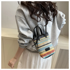 Gros plan détaillé d'un mini sac bandoulière tissé coloré avec poignée en cuir noir