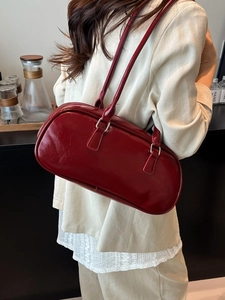 Bolso baguette rojo brillante de piel sintética con doble asa en un entorno de estilo de vida