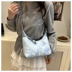 Close-up of light blue bag featuring 3D mesh butterflies and floral lace textures