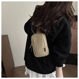 Detailed back view of khaki nylon chest bag with zip pockets and fashion woven label