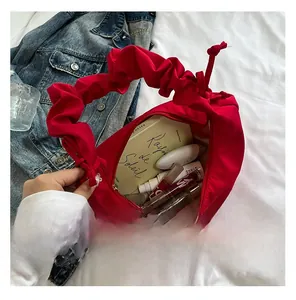 Top view of red pleated crossbody bag showing spacious interior with cosmetics and laptop