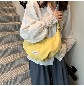 Detail of yellow pleated nylon crossbody bag with Believe in yourself label decoration