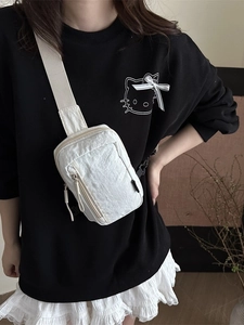 Minimalist white nylon crossbody bag with pleated texture and adjustable strap on a model