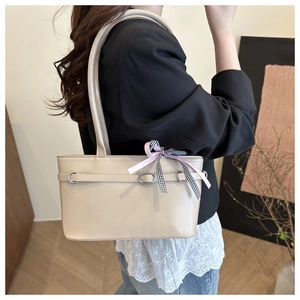 Détail du sac cabas beige avec ruban rose et décoration élégante en anneau métallique