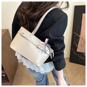 Détail du sac fourre-tout en cuir verni crème avec boucle argentée et ruban