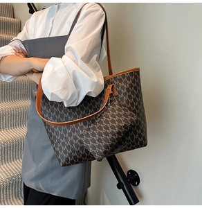 Détail d'un grand sac cabas avec motif M marron et petite pochette assortie