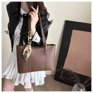 Sac cabas en cuir marron avec foulard vintage porté par un mannequin en style décontracté