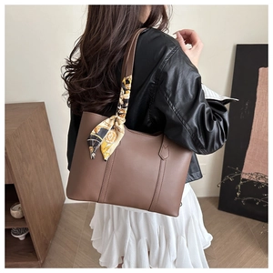 Détail du sac cabas marron mat avec foulard vintage attaché à la bandoulière
