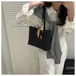 Vue détaillée d'un sac cabas en cuir noir avec un foulard floral décoratif sur la poignée