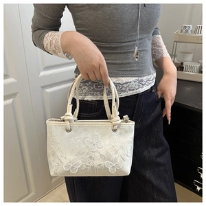 Vue détaillée du sac en dentelle florale blanche avec broderies de papillons en 3D
