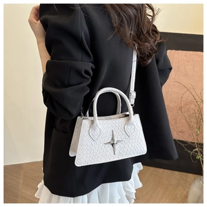 Detail of white textured shoulder bag with silver star buckle worn by a female model