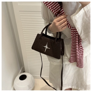 Detailed view of dark brown woven textured mini square bag with silver star ornament