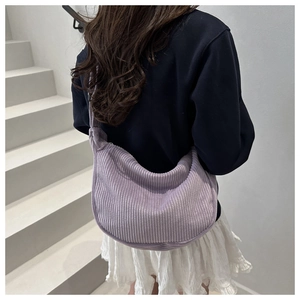 Close-up of lavender corduroy crescent crossbody bag showing soft ribbed fabric texture