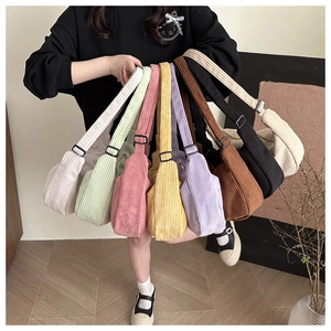 Collection of colorful corduroy crescent bags with adjustable straps in various shades