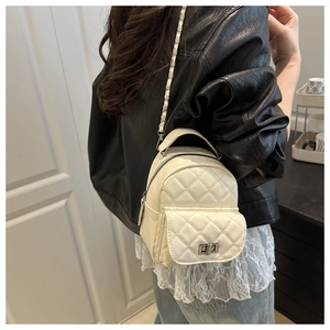 Detail eines cremefarbenen gesteppten Mini-Rucksacks mit silbernem Drehverschluss
