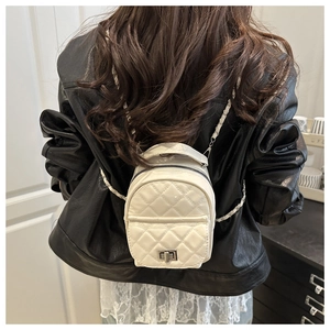 Detailed back view of mini white quilted backpack with chain straps and metallic lock