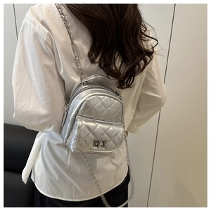 Detailansicht des silbernen gesteppten Rucksacks mit Metallkette und Drehverschluss