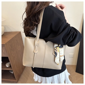 Chic beige tote bag with decorative silk scarf accessory for casual daily commute