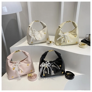 Detail of luxury glossy handbags in white beige pink and black with pearl lace bow charm
