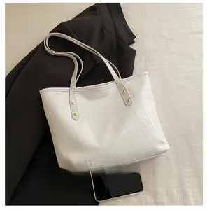 Detailed view of white crocodile embossed tote bag with gold rivets and large capacity