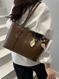 Brown leather tote bag with decorative scarf and shoulder strap for women