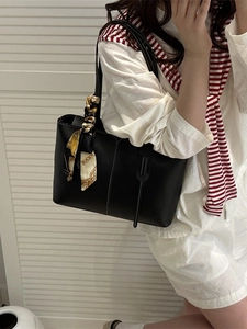 Classic black tote bag with white stitching and decorative silk scarf for women's commute