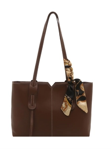 Brown leather tote bag with contrast stitching and decorative silk scarf for commute