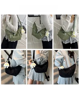 Modèle portant le sac en nylon vert armée et noir avec un porte-clés nuage peluche