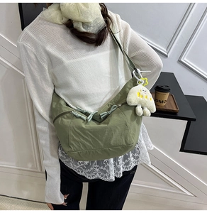 Détail du sac hobo en nylon vert avec fermeture éclair et porte-clés nuage doux
