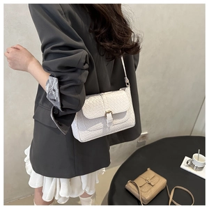 White baguette bag with crocodile texture and metal buckle shown on model's shoulder