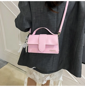 Pink PU leather crossbody bag with pearl and lace bow pendant accessory detail