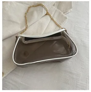 Transparent PVC shoulder bag with gold chain strap shown next to a smartphone for size scale