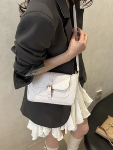 White croc-effect baguette shoulder bag with gold buckle, worn with grey blazer