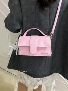 Pink PU leather crossbody bag with fashion lettering and pearl lace charm on model