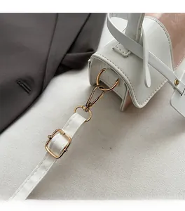 Detailed macro view of premium golden hardware buckles on a two-tone leather handbag