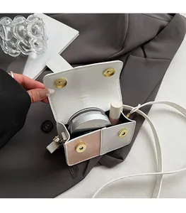 Detail view of mini contrast square bag interior with lipstick and makeup essentials