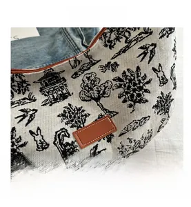Dettaglio del motivo Toile de Jouy sulla borsa a mezzaluna con patch in pelle cucita