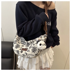White canvas crescent crossbody bag with landscape embroidery and panda charm detail