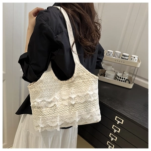 Close-up of tiered lace embroidery and delicate crochet texture on this beige tote bag