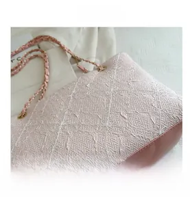 Detail of pink quilted fabric with silver thread and metallic chain shoulder strap
