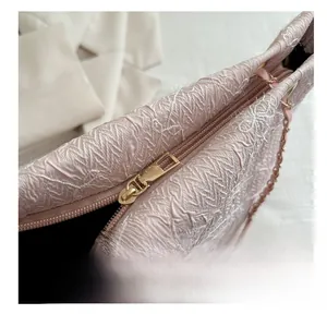 Close-up of pink textured fabric tote bag with butterfly embroidery and golden zipper