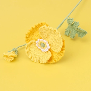 Macro detail of handmade crochet poppy flower with intricate yellow knit texture