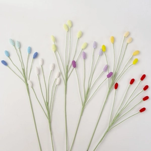 Detailed view of colorful handmade crochet flower buds on green knitted stems