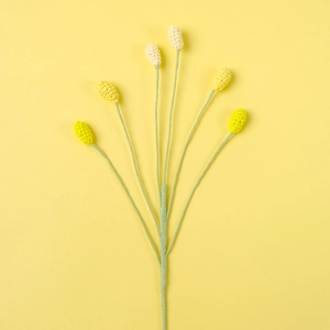 Macro detail of hand-knitted six-head floral branch with yellow and white crochet buds
