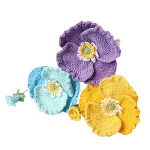 Handmade crochet poppy flower bouquet in purple, blue and yellow on white background
