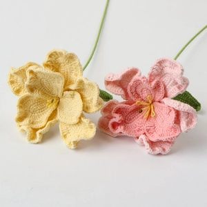 Detail of handmade crochet flowers in yellow and pink with delicate knitted texture